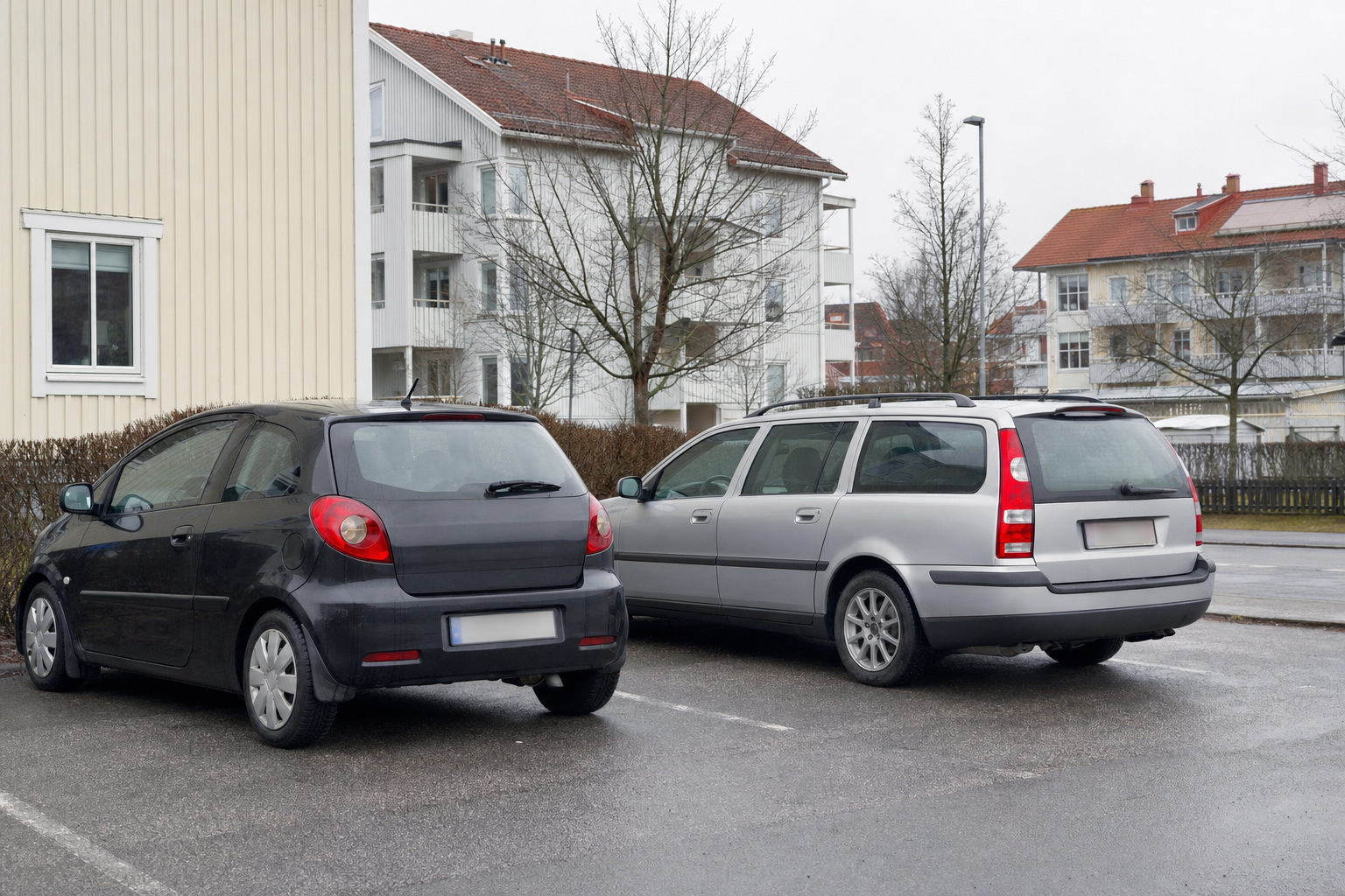 Två bilar parkerade sida vid sida på parkeringsplats